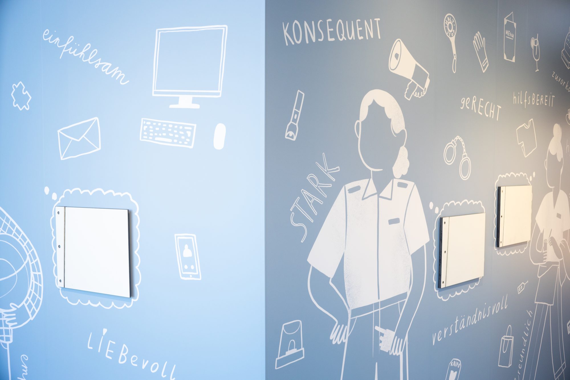 Sondergrafik-Wand mit gedruckten Illustrationen und weiß beschrifteten Begriffen sowie klappbaren Interaktionselementen