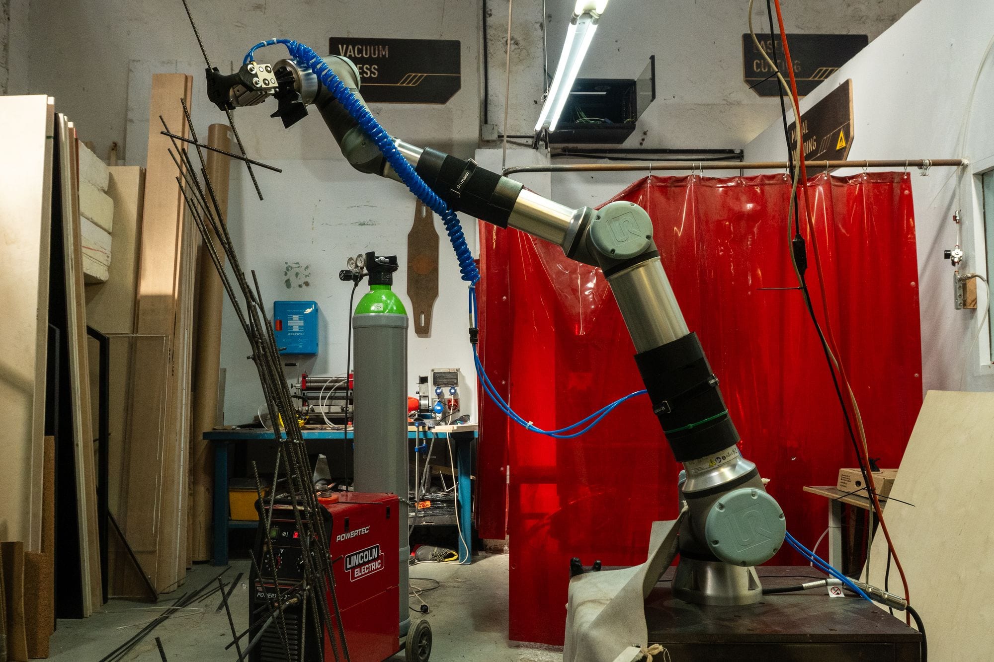 UR-Roboter mit Schweiß-Effektor in der Metallwerkstatt, Bewehrungsstahl im Aufbau
